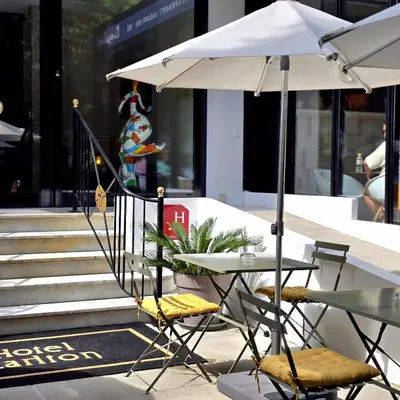 a table and chairs with an umbrella on a sidewalk at Hotel Carlton Nice in Nice