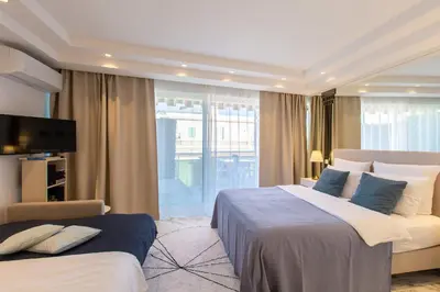 a hotel room with a large bed and a television at ROYAL PROMENADE Pool Terrace Sea View Air Conditioning in Nice