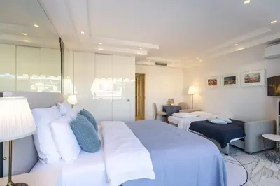 a hotel room with two beds and a living room at ROYAL PROMENADE Pool Terrace Sea View Air Conditioning in Nice