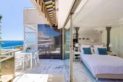 a white kitchen with marble walls and white cabinets at ROYAL PROMENADE Pool Terrace Sea View Air Conditioning in Nice