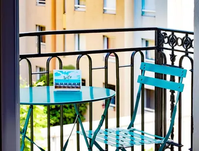 a blue table and a chair on a balcony with a laptop at Hotel So’Co by Happyculture in Nice