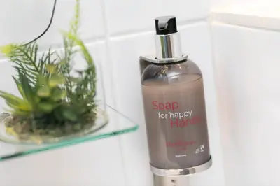 a bottle of soap for happy harbor next to a plant at Hotel So’Co by Happyculture in Nice