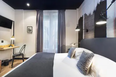 a hotel room with a bed and a desk at Hotel So’Co by Happyculture in Nice