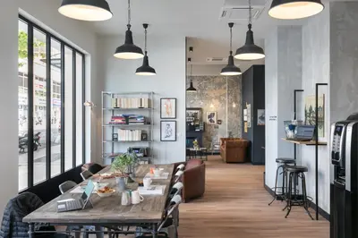 a dining room with a wooden table and chairs at Hotel So’Co by Happyculture in Nice