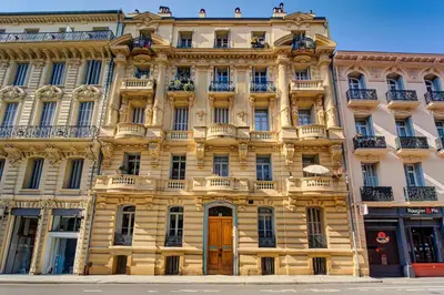 a large yellow building with balconies on a street at L'Écrin Blanc Niçois - Welkeys in Nice