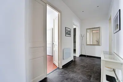 a hallway with white walls and an open door at L'Écrin Blanc Niçois - Welkeys in Nice