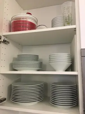 a cupboard filled with white plates and bowls at Apartment on Place Massena in Nice
