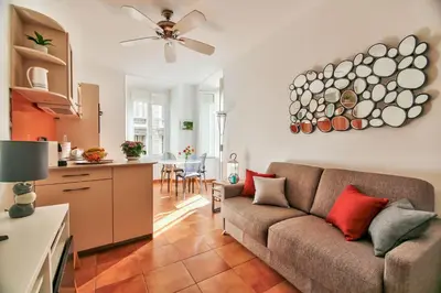 a living room with a couch and a kitchen at L'Olivette in Nice