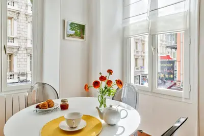 a white table with a vase of flowers on it at L'Olivette in Nice