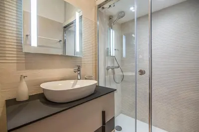 a bathroom with a sink and a glass shower at L'Olivette in Nice