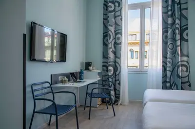 a room with a table and two chairs and a tv at Best Western Alba in Nice