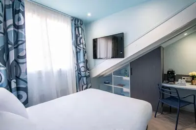 a bedroom with a bed and a desk and a tv at Best Western Alba in Nice