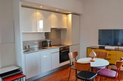 a kitchen with a table and chairs and a kitchen with a sink at Villefranche Sur Mer One Bed in Villefranche-sur-Mer