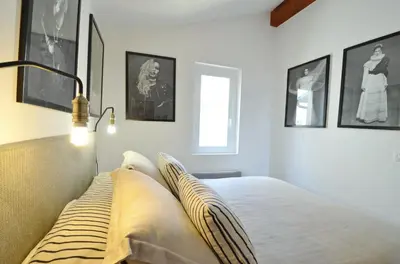 a bedroom with a bed with pillows on it at Villefranche Sur Mer One Bed in Villefranche-sur-Mer