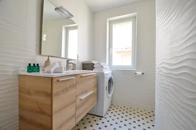 a bathroom with a washing machine and a sink at Villefranche Sur Mer One Bed in Villefranche-sur-Mer