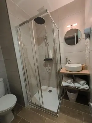 a bathroom with a shower and a toilet and a sink at Hôtel Amaryllis in Nice