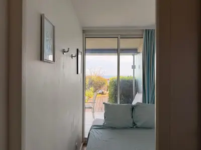 a room with a bed and a sliding glass door at Sunny Home Costa Plana-Monaco -Cap D'Ail in Cap d'Ail