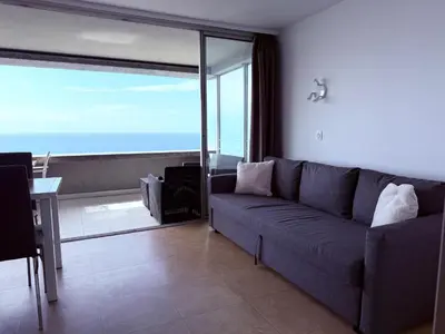 a living room with a couch and a view of the ocean at Sunny Home Costa Plana-Monaco -Cap D'Ail in Cap d'Ail