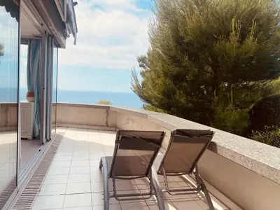 two chairs sitting on a balcony looking out at the ocean at Sunny Home Costa Plana-Monaco -Cap D'Ail in Cap d'Ail