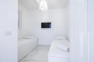 a white bathroom with a bed and a tv at Sea view - 2 Bdr Promenade des Anglais in Nice