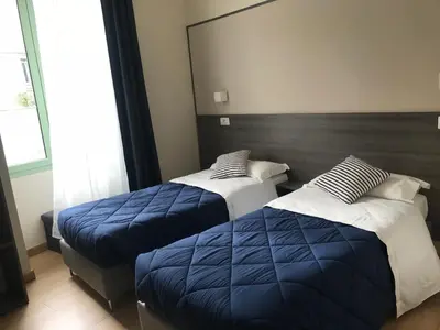 a bedroom with two beds and a large mirror at Boutique Hôtel Neptune Nice in Nice