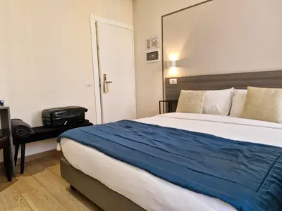 a bedroom with a large bed with a blue blanket at Boutique Hôtel Neptune Nice in Nice