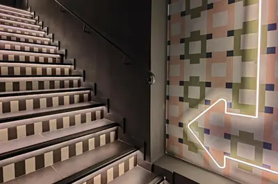 an empty stairs with a neon sign on the wall at Hotel Aparthotel AMMI Nice Lafayette in Nice
