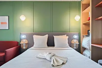a bedroom with a bed with towels on it at Hotel Aparthotel AMMI Nice Lafayette in Nice