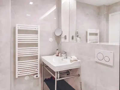 a white bathroom with a sink and a mirror at Hotel Aparthotel AMMI Nice Lafayette in Nice