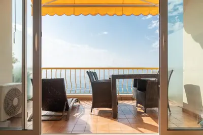 a balcony with a table and chairs and a view of the ocean at Beachfront apartment Promenade Des Anglais in Nice