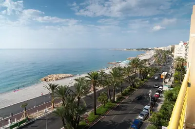 a view of the beach and the ocean from a building at Beachfront apartment Promenade Des Anglais in Nice