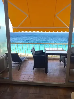 a view of the ocean from a room with a table and chairs at Beachfront apartment Promenade Des Anglais in Nice