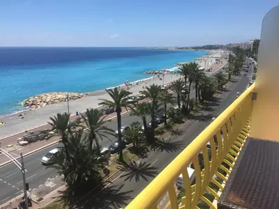 a balcony with a view of a beach and the ocean at Beachfront apartment Promenade Des Anglais in Nice