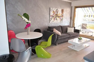 a living room with a couch and a table and chairs at Royal Lux NICE -Last floor, see view in Nice