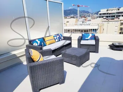 a balcony with wicker chairs and pillows on a roof at Royal Lux NICE -Last floor, see view in Nice