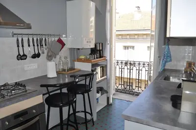 a kitchen with three bar stools in a kitchen with a window at Appartement carre d'or in Nice