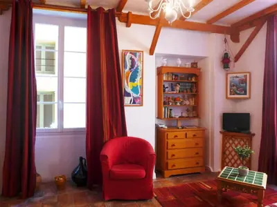 a living room with a red chair and a dresser at Apartment Miralheti by Interhome in Nice