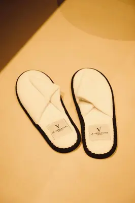 a pair of white flip flops sitting on a table at Hôtel Le Versailles in Villefranche-sur-Mer