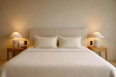 a bedroom with a large white bed with two lamps at Hôtel Le Versailles in Villefranche-sur-Mer