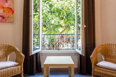 two chairs and a table in front of a window at Hotel Select in Beaulieu-sur-Mer