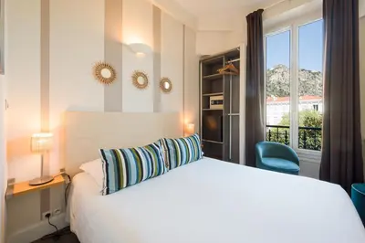 a hotel room with a bed and a window at Hotel Select in Beaulieu-sur-Mer