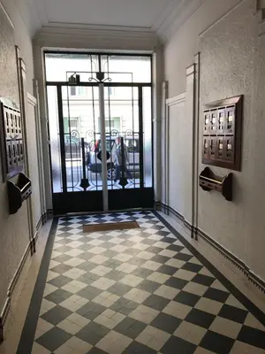 a lobby with a checkered floor and a glass door at Palais Haydee in Nice
