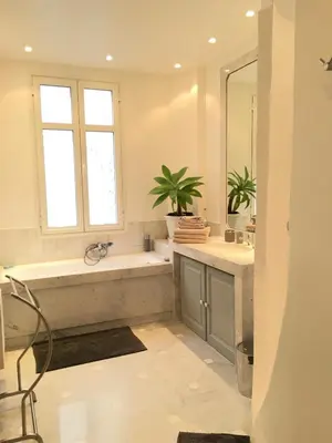 a bathroom with a tub and a sink and a mirror at Palais Haydee in Nice