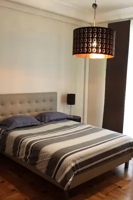 a bedroom with a large bed with a lamp at Palais Haydee in Nice