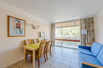 a living room with a dining room table and a couch at Residence Heliotel Marine - maeva Home in Saint-Laurent-du-Var