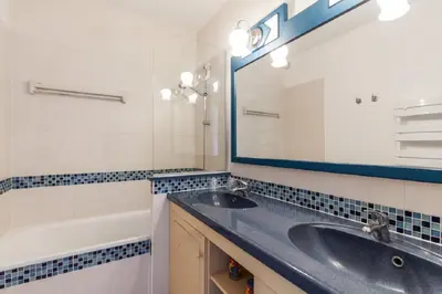 a bathroom with a sink and a mirror and a tub at Residence Heliotel Marine - maeva Home in Saint-Laurent-du-Var