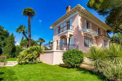 a large pink house with a palm tree at Stunning seaview villa. Villefranche Sur Mer in Villefranche-sur-Mer