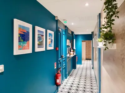 a hallway with blue walls and a fire extinguisher at Nice Home - Studios Lido in Nice