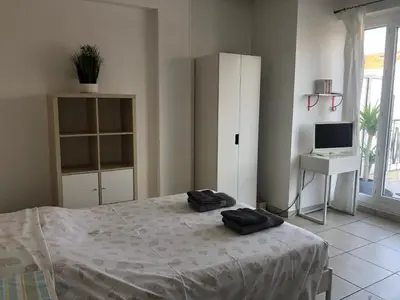 a bedroom with a bed and a desk with a computer at Appartement Terrasse Quartier Liberation in Nice