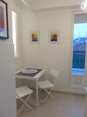 a dining room with a table and chairs and a window at Appartement Terrasse Quartier Liberation in Nice